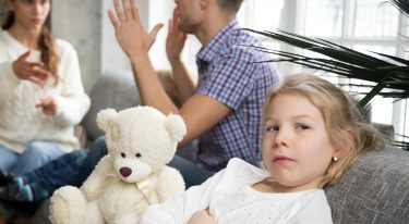 Little upset girl daughter depressed with parents arguments or d